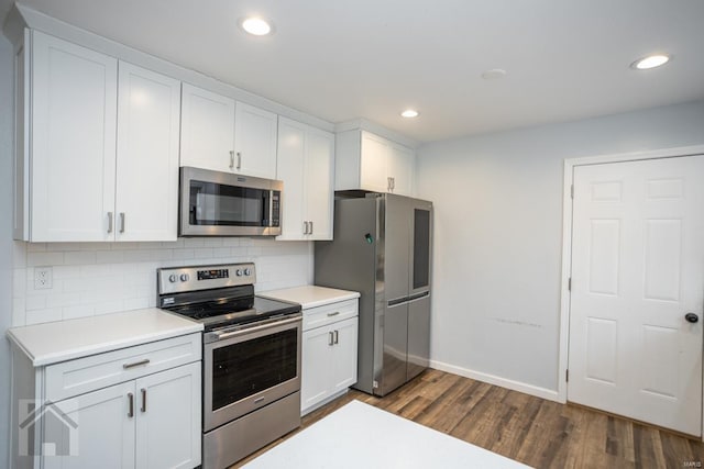 kitchen with white cabinets, backsplash, stainless steel appliances, and dark hardwood / wood-style floors