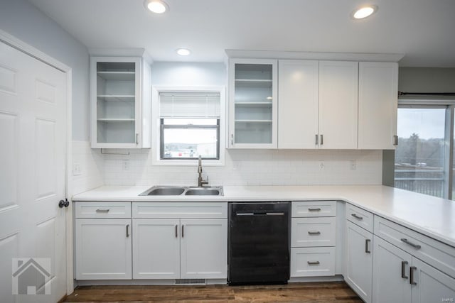 kitchen with white cabinets, sink, black dishwasher, and tasteful backsplash