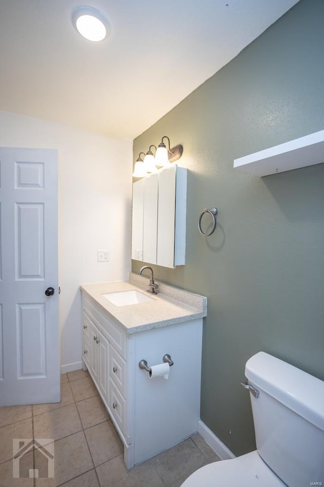 bathroom with tile patterned flooring, vanity, and toilet