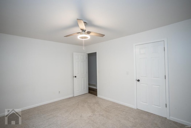 empty room featuring ceiling fan and light carpet