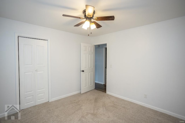 unfurnished bedroom with ceiling fan, light carpet, and a closet