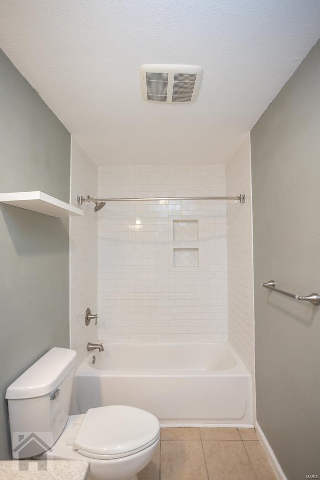 bathroom featuring toilet, tile patterned floors, and tiled shower / bath