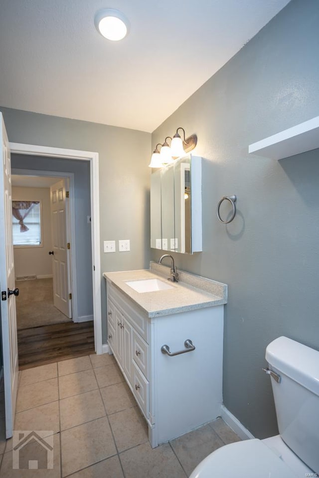 bathroom featuring tile patterned floors, vanity, and toilet