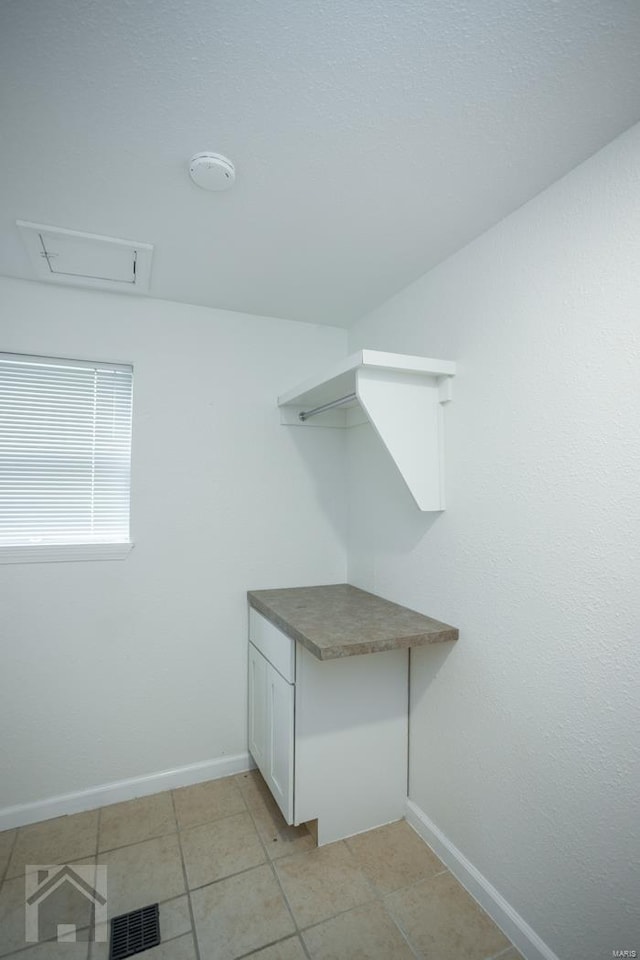 walk in closet with light tile patterned floors