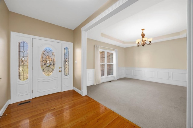 entryway with wood-type flooring and a notable chandelier