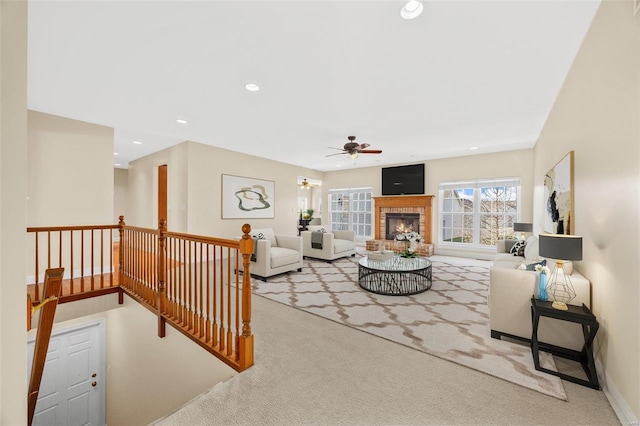 living room with ceiling fan, light carpet, and a brick fireplace