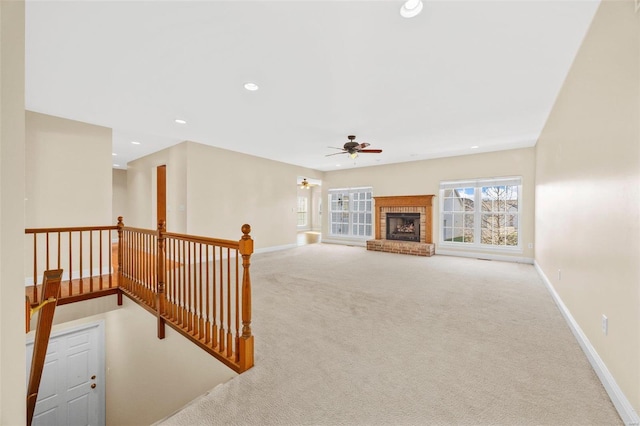 living room featuring light carpet, ceiling fan, and a brick fireplace