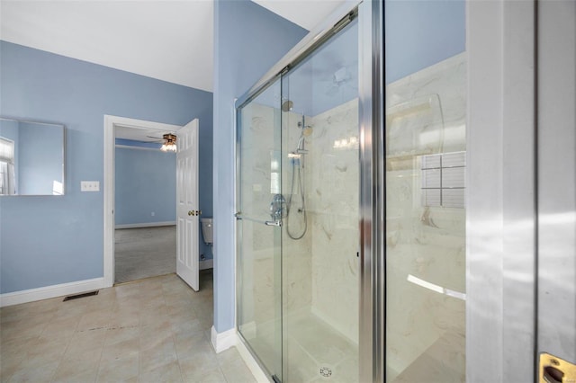 bathroom with tile patterned floors, ceiling fan, and a shower with shower door