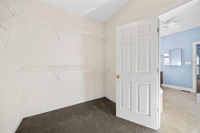 walk in closet featuring carpet flooring, ceiling fan, and vaulted ceiling