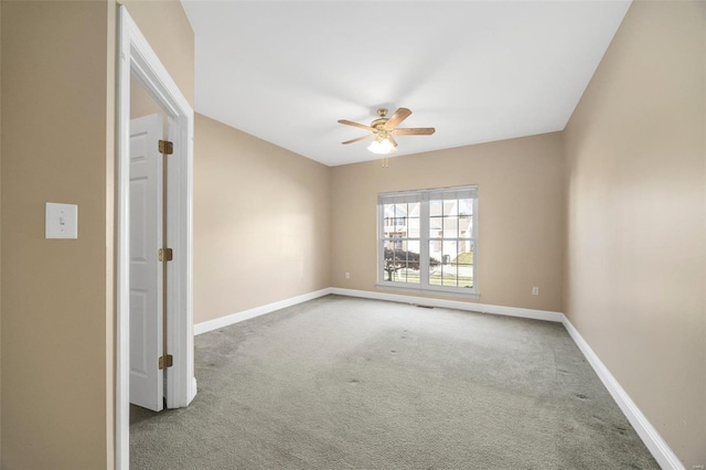 carpeted spare room featuring ceiling fan