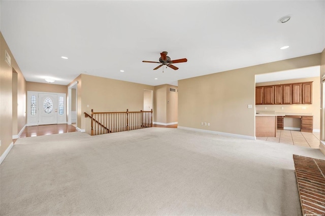 carpeted spare room featuring ceiling fan