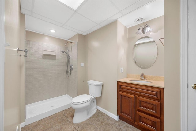 bathroom with tile patterned floors, vanity, toilet, and a tile shower