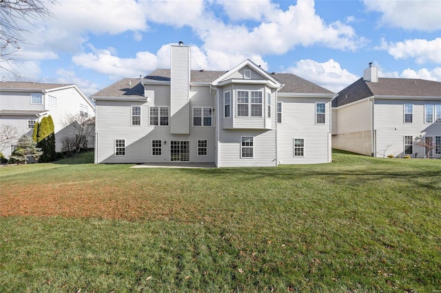 rear view of property with a yard and a patio