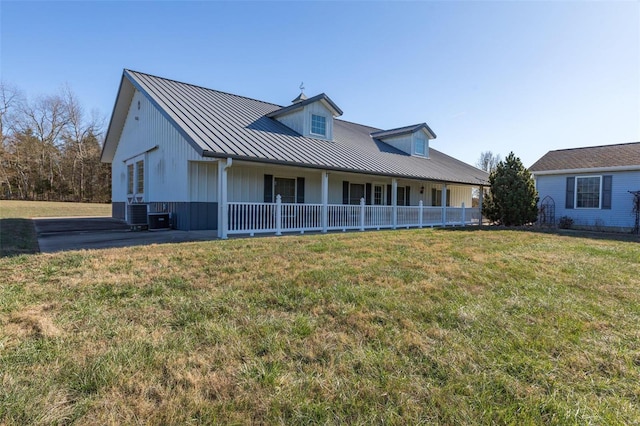 view of front facade with cooling unit, covered porch, and a front yard