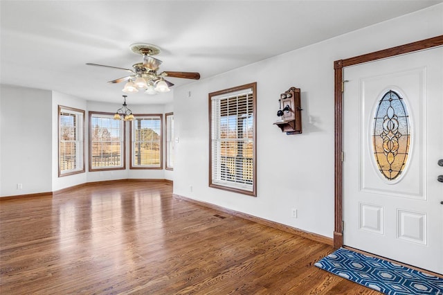 foyer featuring ceiling fan with notable chandelier and hardwood / wood-style flooring