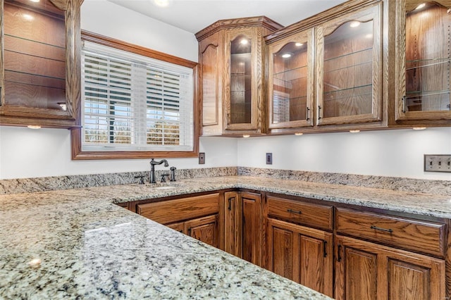 kitchen featuring light stone countertops and sink