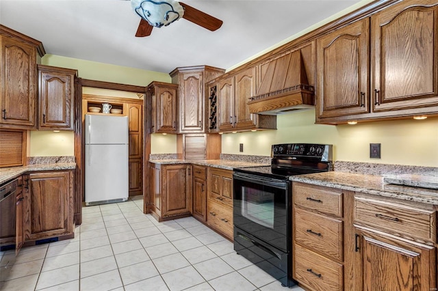 kitchen featuring black range with electric stovetop, light stone counters, white fridge, and custom exhaust hood