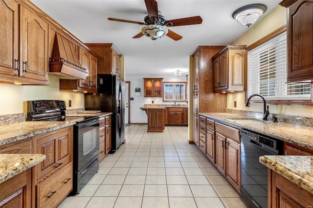 kitchen featuring black appliances, sink, light tile patterned floors, light stone counters, and custom range hood