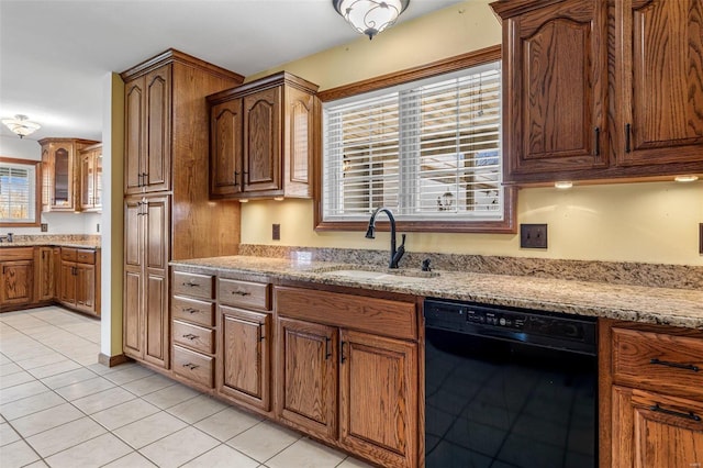 kitchen with sink, light tile patterned floors, black dishwasher, and a wealth of natural light