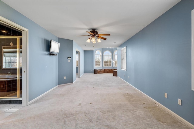 unfurnished living room with light carpet and ceiling fan