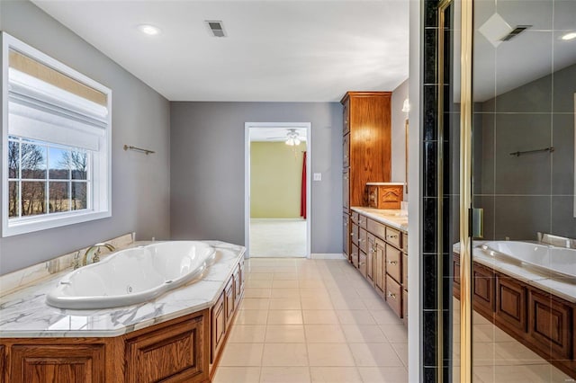 bathroom with plus walk in shower, tile patterned flooring, and vanity