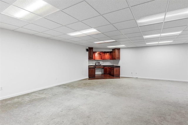 unfurnished living room featuring a paneled ceiling and light colored carpet