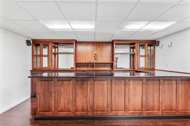 bar with a paneled ceiling and dark hardwood / wood-style flooring