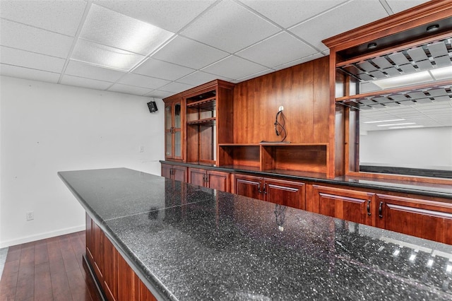 bar with a paneled ceiling and dark hardwood / wood-style flooring