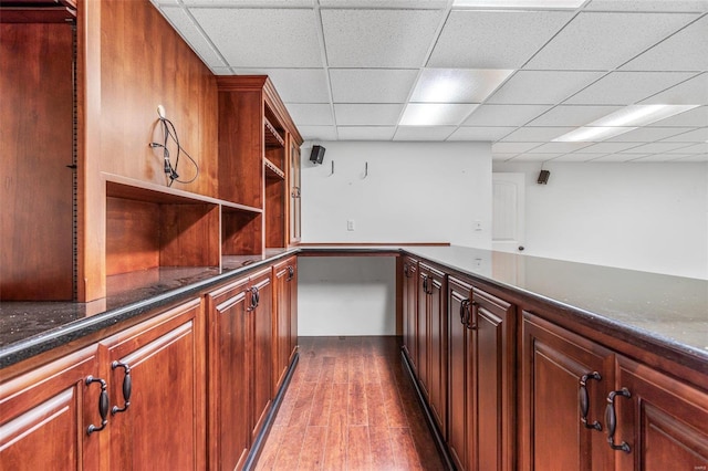 bar featuring dark hardwood / wood-style floors and a drop ceiling