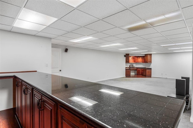 bar with a drop ceiling and dark wood-type flooring