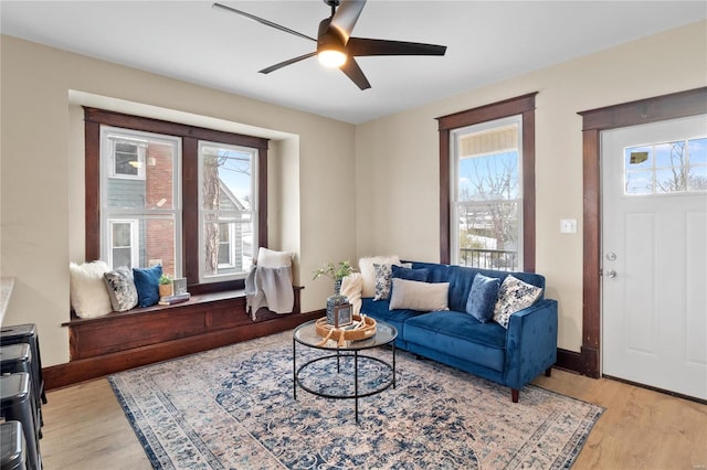 living room with ceiling fan, a healthy amount of sunlight, and light wood-type flooring