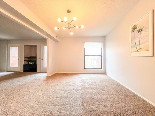 carpeted spare room featuring a chandelier