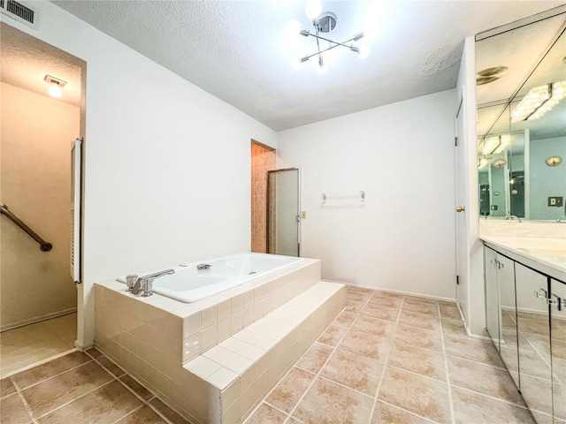 bathroom with tile patterned flooring, shower with separate bathtub, a textured ceiling, and vanity