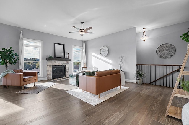 living room featuring a fireplace, ceiling fan, and dark hardwood / wood-style flooring