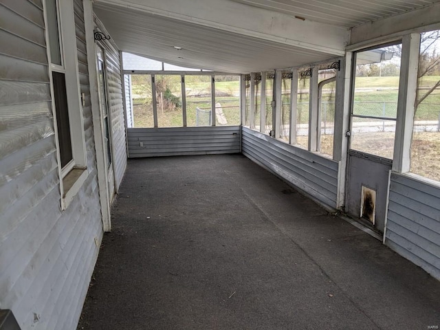 unfurnished sunroom featuring vaulted ceiling