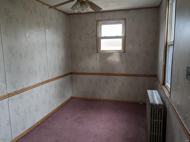 empty room with carpet flooring, radiator, and ceiling fan