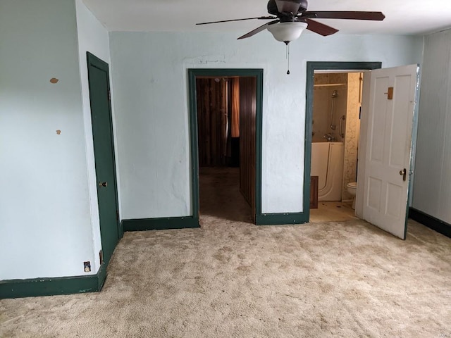 unfurnished bedroom with connected bathroom, light carpet, and ceiling fan