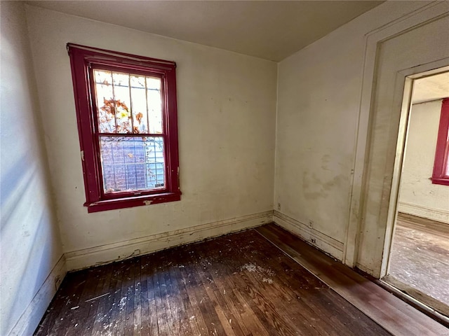 unfurnished room with dark wood-type flooring