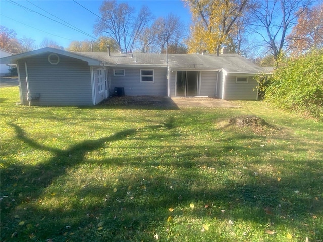 back of property featuring central AC unit and a lawn