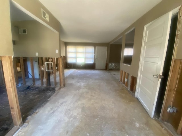 unfurnished living room featuring concrete flooring