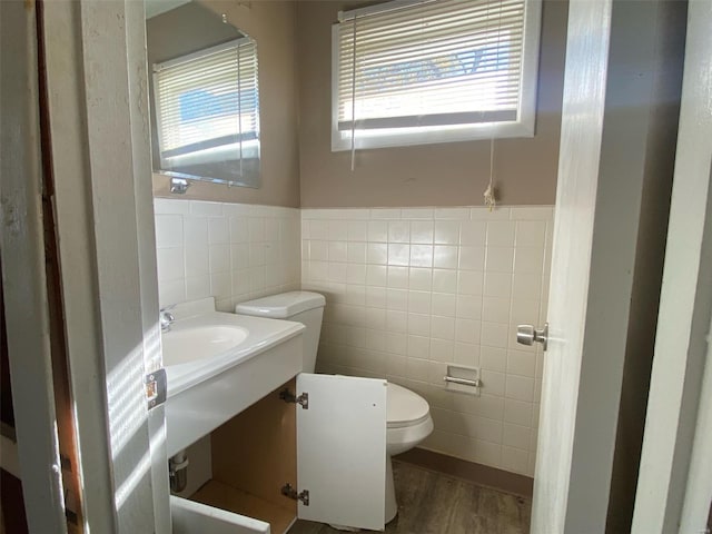 bathroom featuring hardwood / wood-style floors, tile walls, and toilet