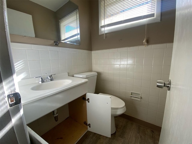 bathroom featuring hardwood / wood-style floors, toilet, tile walls, and sink