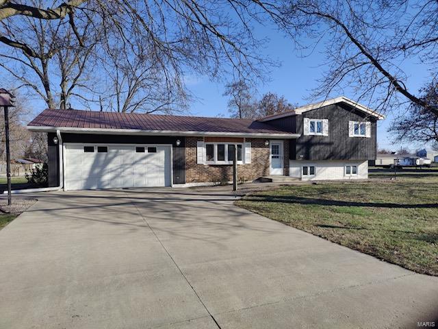 tri-level home with a front yard and a garage