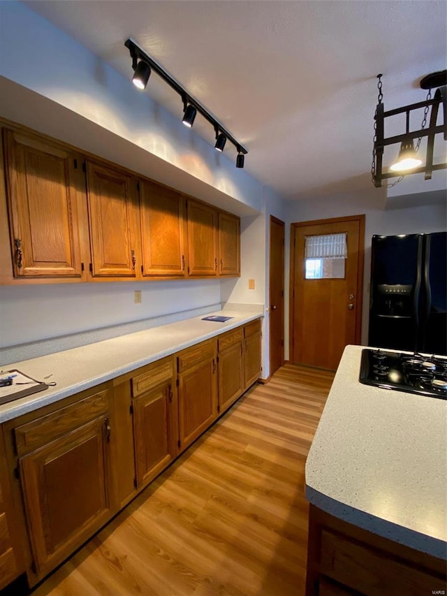 kitchen featuring light hardwood / wood-style flooring, black appliances, and track lighting