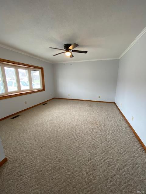 unfurnished room featuring crown molding, carpet floors, and ceiling fan