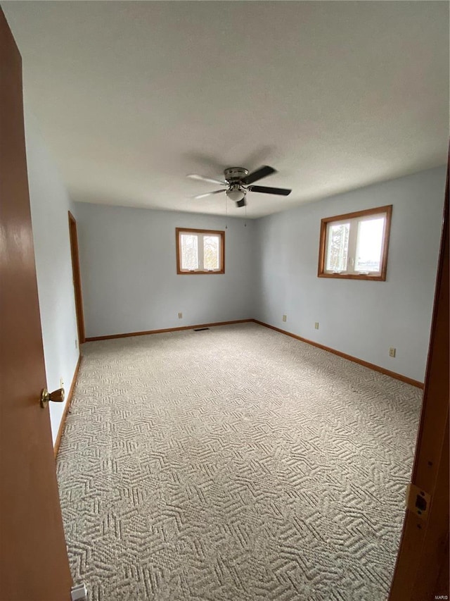 unfurnished room featuring ceiling fan and light carpet