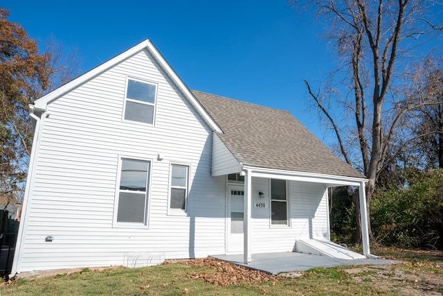 rear view of house featuring a yard