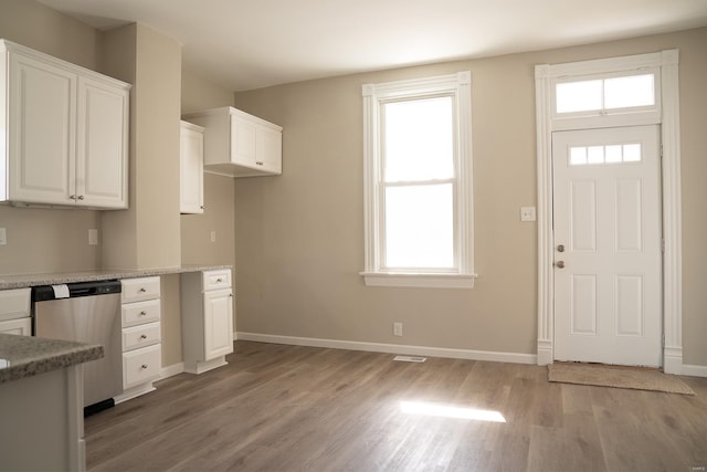 kitchen featuring white cabinetry, dishwasher, light hardwood / wood-style floors, and plenty of natural light