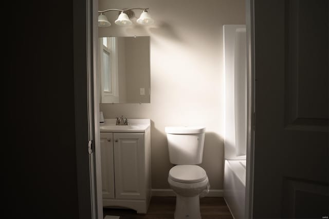 bathroom with vanity, toilet, wood-type flooring, and a tub to relax in