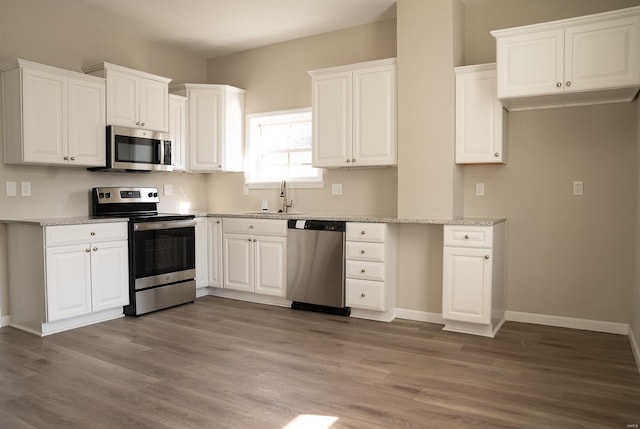 kitchen with white cabinetry, sink, stainless steel appliances, and light wood-type flooring